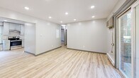 Located at 149 Ashford Center Rd in Ashford, Connecticut, this single-floor unit has been thoughtfully renovated with clean, modern finishes throughout. Light wood laminate flooring runs consistently across all rooms, creating a bright and cohesive aesthetic complemented by crisp white walls and gray baseboards.

The open living area is illuminated by recessed lighting and features a wall-mounted AC unit alongside baseboard heaters. Sliding glass doors lead directly to a private deck overlooking lush greenery, filling the space with natural light and offering pleasant outdoor views.

The kitchen is well-appointed with gray shaker-style cabinetry, granite-look countertops, a subway tile backsplash, and a full suite of stainless steel appliances including a range, dishwasher, refrigerator, and sink. Natural light enters through a window above the sink, adding to the room's airy feel.

The bedrooms are comfortably sized, each featuring windows with blinds that frame views of the surrounding trees, baseboard heating, and light-filled interiors. One bedroom includes a built-in closet with shelving for added storage.

The bathroom is a standout feature, finished with large-format wood-look and stone-look tile, a soaking tub, a rain showerhead, a recessed niche, and brushed nickel fixtures, delivering a spa-like atmosphere.