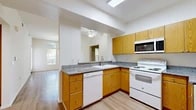 Located at 353 S Tustin St in Orange, CA, this single-story 1-bedroom, 1-bathroom residence offers a well-organized and efficiently designed floor plan. Light-toned laminate wood flooring runs throughout, lending a clean and cohesive look to every room.

The open kitchen and living area serves as the heart of the home. The kitchen features warm oak cabinetry, granite-look countertops, a full suite of white appliances including a range, built-in microwave, and dishwasher, as well as a skylight that draws in natural light. A pass-through counter connects seamlessly to the living area, which is brightened by a ceiling fan and large windows with outdoor views.

The generously sized primary bedroom provides a comfortable retreat with a large barred window that fills the room with natural light. A well-appointed walk-in closet with wire shelving and organizational systems offers ample storage, complemented by a second closet elsewhere in the unit.

The bathroom is clean and functional, featuring wood-tone cabinetry, a tub/shower combination, and accessibility grab bars. An additional den provides flexible space suitable as a home office or secondary sleeping area. A hallway connects the living spaces efficiently, completing this thoughtfully laid-out residence.