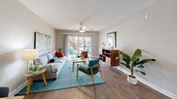 Located on Eden Isle Blvd NE in Saint Petersburg, FL, this well-appointed one-bedroom, one-bathroom residence offers a thoughtfully designed single-floor layout that maximizes every square foot of living space. The living room serves as the heart of the home, featuring warm hardwood-style flooring, a ceiling fan, and a sliding glass door that floods the area with natural light and provides access to an outdoor patio. Vibrant tropical-inspired wall art and a cohesive color palette of teal and orange accents lend the space a lively, Florida-inspired character. A dedicated dining nook sits adjacent to the living area, adding functional versatility. The kitchen is outfitted with crisp white shaker cabinetry, granite-look countertops, stainless steel appliances including a range, over-the-range microwave, and dishwasher, plus a window above the sink that brings in natural light. The generously sized bedroom features plush carpeting, a ceiling fan, a window with views of lush Florida greenery, and direct access to the bathroom. The full bathroom includes a single-sink vanity with granite-look countertops, white cabinetry, and a shower-tub combination with a window for ventilation. Clean, neutral wall tones and consistent finishes throughout create a cohesive and comfortable living environment.