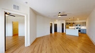 Located at 6121 Alma Rd in McKinney, TX, this thoughtfully designed one-bedroom, one-bathroom unit offers a clean, modern aesthetic throughout its single-floor layout. Light wood-tone flooring runs seamlessly across all living areas, complementing the bright white walls and creating a warm, cohesive ambiance.

The open-concept kitchen and living room serves as the heart of the unit. The kitchen features gray shaker-style cabinetry with matte black hardware, white countertops, a white subway tile backsplash, stainless steel refrigerator, and a built-in wine rack — all anchored by stylish pendant lighting. The living area is generously proportioned, bathed in natural light from multiple windows and a glass-panel entry door, and topped with a ceiling fan.

The bedroom offers a comfortable, well-lit retreat with a ceiling fan, a large window with exterior views, and direct access to a spacious walk-in closet outfitted with wire shelving systems for ample storage.

The bathroom is a standout feature, showcasing a marble-look surround on the tub/shower combo, matte black fixtures, a gray vanity with a white countertop, and a coordinating mirror. In-unit laundry with a full-size washer and dryer adds everyday convenience, completing this well-appointed home.