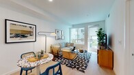 Located at 310 Del Sol Dr in San Diego's Mission Valley neighborhood, this well-appointed single-floor residence showcases a thoughtfully designed open-concept layout with clean, modern aesthetics throughout. Light wood flooring flows seamlessly across the living areas, complemented by crisp white walls and abundant natural light streaming in through large windows and a glass door leading to a private balcony with community views.

The open living and dining area offers a comfortable, airy atmosphere, anchored by a terrazzo-topped dining table and a welcoming seating arrangement. The kitchen is a standout feature, boasting sage-green cabinetry, stainless steel appliances including a gas range, microwave, refrigerator, and dishwasher, along with a white quartz peninsula that provides additional seating and prep space. A penny-tile backsplash adds a refined finishing touch.

The two bedrooms are bright and serene, each featuring large windows, light wood flooring, and ample space. The bathrooms are finished with warm wood-toned floating vanities, white quartz countertops, and backlit mirrors, creating a spa-like feel. Throughout the residence, the design reflects a cohesive coastal-modern sensibility, making it a refined and comfortable home in the heart of San Diego.