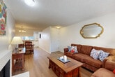 Located at 702 W Casino Rd in Everett, WA, this well-organized 2-bedroom, 1-bathroom residence offers a practical and comfortable single-floor layout. The living room serves as the heart of the home, featuring light hardwood-style flooring, a classic brick fireplace, a textured ceiling, and a sliding glass door that fills the space with natural light and provides outdoor views. The open flow connects seamlessly to the dining area, which is illuminated by a chandelier and benefits from a pass-through window to the kitchen, enhancing the sense of connectivity. The galley-style kitchen is efficiently designed with white cabinetry, a full suite of appliances including a dishwasher and refrigerator, light countertops, and a window overlooking the outdoors. Both bedrooms are carpeted and offer a calm, restful atmosphere. The primary bedroom is generously sized with room for a full furniture arrangement and includes access to a hallway connecting to the second bedroom. Two closets provide ample storage throughout. The bathroom features a full tub-shower combination with white tile surround and a window for natural ventilation. A connecting hallway ties all rooms together for an efficient and functional flow throughout the residence.