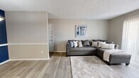 Located in Ridgeland, MS, this 2-bedroom, 2-bathroom single-floor residence offers a thoughtfully laid-out floor plan designed for comfortable, everyday living. The living room serves as the heart of the home, featuring wood-look plank flooring, neutral warm-toned walls, and a textured ceiling. A sliding glass door with vertical blinds fills the space with natural light and provides access to an outdoor patio, while a wall-mounted TV adds a modern touch. The galley-style kitchen is efficiently designed with white cabinetry, light quartz countertops, wood-look flooring, and stainless steel appliances, including a refrigerator, dishwasher, and electric range. The primary bedroom is generously sized with plush carpet flooring, a ceiling fan, and a closet with mirrored sliding doors and built-in shelving. The second bedroom also features carpet, a ceiling fan, a natural window, and its own closet. Both bathrooms are clean and functional — one features a white vanity with a quartz countertop and framed mirror, while the other includes a tub-shower combination. A hallway connects the rooms, completing this well-organized and move-in-ready home.