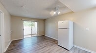 Located at 1371 Parkside Dr in San Bernardino, CA, this efficiently designed single-story unit offers a well-utilized layout across a compact footprint. The interior features consistent wood-look laminate flooring throughout, neutral beige walls, and textured ceilings, creating a cohesive and understated aesthetic.

The kitchen is thoughtfully arranged in a galley-style configuration, equipped with upper cabinetry, a range hood, a stainless steel sink with white countertops, a built-in electric range with oven, and a full-size refrigerator. A ceiling fan with a light fixture provides additional airflow and illumination in this area.

The bedroom offers a comfortable, private space with a wall-mounted PTAC heating and cooling unit, a window with blinds framing views of surrounding greenery, and a closet accessible via sliding doors. Natural light filters in through the window, enhancing the room's openness.

The bathroom includes a full tub and shower combination with white surround panels, chrome fixtures, and safety grab bars, reflecting a practical and accessible design. White trim and clean finishes are consistent throughout the unit, contributing to a tidy, move-in-ready presentation.