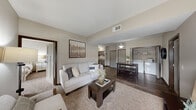 This well-appointed two-bedroom, two-bathroom residence in Billings, Montana offers a thoughtfully designed single-level layout that maximizes comfort and functionality. The open-concept living and dining area serves as the heart of the home, featuring warm wood-look flooring, neutral toned walls, and vaulted ceiling details that create an airy, inviting atmosphere. The living area flows seamlessly into the dining space and kitchen, making it ideal for everyday living and entertaining.

The kitchen is a standout feature, boasting rich dark-toned cabinetry, striking granite countertops, stainless steel appliances, and a central island with bar seating and pendant lighting overhead — combining style with practicality. A dedicated in-unit laundry area is conveniently located just off the main living space.

Both bedrooms are well-sized and carpeted for comfort, with the primary bedroom offering access to a private bathroom featuring granite countertops, dark wood cabinetry, and elegant lighting fixtures. Each bedroom benefits from generous closet space, including a walk-in closet outfitted with wire shelving systems for organized storage. Natural light flows through the bedroom windows, adding warmth to the neutral, calming palette found throughout the entire residence.