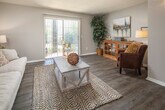 Located at 1900 Rice Mine Rd N in Tuscaloosa, Alabama, this single-floor residence offers a well-organized layout with a comfortable blend of functional design and modern finishes throughout. The living room serves as the heart of the home, featuring durable dark hardwood-style flooring, neutral gray walls, and a textured ceiling. A large sliding glass door fills the space with natural light and provides direct access to an outdoor area, creating an open and airy atmosphere. The room flows seamlessly into a hallway connecting the remaining areas of the home. The galley-style kitchen is efficiently designed with white cabinetry, granite-style countertops, and black appliances including an electric range and full-size refrigerator, complemented by light hardwood-style flooring. The bedroom is a calm retreat, offering plush carpeting, soft neutral tones, and two windows that allow for generous natural light. The full bathroom features wood-style flooring, a white vanity with granite-style countertops, a well-lit mirror with overhead lighting, and a shower-tub combination. Throughout the residence, a cohesive neutral color palette and consistent flooring choices create a unified, inviting living environment suited for comfortable everyday living.