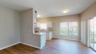 This single-story residence at 3485 Pinewalk Dr N in Margate, Florida offers a well-designed, open-concept layout finished with consistent wood-style flooring throughout. The living area is generously sized, highlighted by large windows fitted with vertical blinds that invite abundant natural light and provide views of the surrounding greenery. A sliding glass door further connects the interior to the outdoors, enhancing the bright and airy atmosphere.

The kitchen is efficiently designed in a galley configuration and opens to the living and dining areas via a peninsula with granite countertops, making it ideal for both cooking and casual interaction. White shaker-style cabinetry lines the walls, complemented by granite countertops, a stainless steel sink, and a full suite of stainless steel appliances including a refrigerator, range, microwave, and dishwasher.

The primary bedroom features wood-style flooring, a large window with garden views, mirrored closet doors, and direct access to an en-suite bathroom. This bathroom includes a dual-sink vanity with granite countertops, white cabinetry, and a tub-shower combination with white tile surround. A second bathroom of similar design provides a tub-shower combination, also finished with white tile. Textured ceilings and neutral-toned walls are consistent throughout the home.