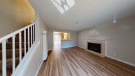 Located at 33300 Mission Blvd in Union City, California, this two-story home offers a well-organized layout across two levels. The main floor welcomes you through a front entry door with an arched window, opening into a spacious living area finished with durable hardwood-style flooring. A tiled fireplace serves as a focal point in the living room, adding warmth and character. A wall-mounted heater unit provides additional climate control. The living room flows seamlessly toward the kitchen, which is accessible via a pass-through opening. The kitchen features warm oak cabinetry, granite-style countertops, a tile backsplash, and white appliances including a coil-top range and refrigerator. The bathrooms are appointed with granite-topped white vanities and hardwood-style flooring; one bathroom includes a shower-tub combo with sliding glass doors and a privacy window. Upstairs, the bedrooms are carpeted for comfort and equipped with ceiling fans and windows that invite natural light. The textured ceilings throughout add a classic finish to each room. A spacious attached garage with an automatic opener and a clean epoxy-coated floor rounds out this home, providing ample storage and parking.