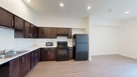 Located at 2312 F Ave in National City, CA, this single-floor, 2-bedroom, 1-bathroom residence offers a clean, modern design with a cohesive aesthetic throughout. Light-toned hardwood flooring flows seamlessly across the entire unit, complementing the bright, white walls that give the space an open and airy feel.

The kitchen is a standout feature, outfitted with rich dark espresso cabinetry that extends to the ceiling for ample storage, white countertops, and a full suite of black appliances including a range, refrigerator, dishwasher, and microwave. The L-shaped layout maximizes counter space and functionality.

Both bedrooms are well-proportioned, featuring the same warm hardwood flooring, neutral walls, and windows dressed with vertical blinds that allow for adjustable natural light. The primary bedroom offers a comfortable footprint with closet access. The secondary bedroom mirrors this clean, versatile design.

The bathroom is finished in a crisp, all-white palette, complete with a tub-shower combination, modern chrome fixtures, and a toilet — all set against the same light wood flooring that carries through the rest of the unit.

Overall, this residence presents a contemporary, move-in-ready aesthetic with consistent finishes, efficient use of space, and a bright, neutral design that adapts easily to various furnishing styles.