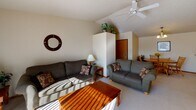 Located at 1714 Dublin Trail in Neenah, Wisconsin, this single-floor residence offers a well-organized and comfortable layout designed for practical everyday living. The living room serves as the heart of the home, highlighted by vaulted ceilings and a ceiling fan that enhance the sense of openness and airflow. A sliding glass door floods the space with natural light and provides outdoor access, while plush carpeting adds warmth underfoot. Adjacent to the living room, the dining area features a welcoming round oak table beneath neutral-toned walls, creating an inviting space for meals and gatherings. The kitchen is efficiently designed in a U-shaped configuration, outfitted with light wood cabinetry, recessed lighting, ample counter space, and full white appliances including a range, dishwasher, and refrigerator. The bedrooms are carpeted and tranquil, with one bedroom offering a window with natural light and generous dresser storage, and another featuring a walk-in closet. The bathrooms are clean and functional, finished with light wood vanities, large mirrors, and neutral countertops. Throughout the home, a consistent neutral color palette and warm wood accents contribute to a cohesive and comfortable atmosphere.