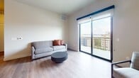 This 830-square-foot, two-bedroom, one-bathroom apartment at 128 Langdon Street in Madison, Wisconsin offers a modern, open-concept layout spread across a single floor. The combined kitchen and living area serves as the heart of the unit, featuring light hardwood-style flooring throughout. The kitchen is equipped with stainless steel appliances, gray cabinetry with gold-tone hardware, a white quartz waterfall island with bar seating, subway tile backsplash, and striking dome pendant lights. The bright living area opens directly onto a private balcony through large sliding glass doors, offering sweeping views of the Madison skyline and Lake Monona. Both bedrooms are well-proportioned with large windows showcasing city and lake views, and the primary bedroom measures 160 square feet. A dedicated closet features wire shelving systems and hardwood-style flooring, providing ample storage. Double doors with sleek hardware add a refined touch to the bedroom. The bathroom is clean and contemporary, finished with a white vanity, round mirror, and chrome fixtures. Neutral tones, clean lines, and abundant natural light give the entire unit a fresh, modern ambiance ideal for urban living in the heart of Madison.
