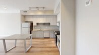 This contemporary apartment in Stamford, CT offers 1580 square feet of thoughtfully designed living space. The open floor plan seamlessly integrates the living room and kitchen, creating an inviting atmosphere for both relaxation and entertainment. The kitchen boasts modern appliances, ample cabinetry, and a central island, perfect for culinary enthusiasts.

The primary bedroom, an impressive 1030 square feet, provides a luxurious retreat with ample space for a sitting area or home office. A second bedroom offers versatility for guests or a dedicated workspace. The bathroom features a large, illuminated mirror and modern fixtures, blending functionality with style.

Natural light floods the space through large windows, while two balconies offer outdoor living and picturesque views of the surrounding area, including colorful recreational spaces. The neutral color palette and warm wood flooring throughout create a cohesive, contemporary aesthetic.

Additional features include central air conditioning, in-unit laundry, and ample storage space. The property's location in Stamford provides easy access to urban amenities while offering a comfortable, modern living environment.