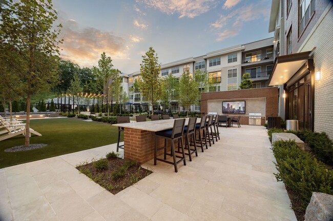 Resident courtyard featuring multiple grilling stations and outdoor dining areas - Hanover Weymouth