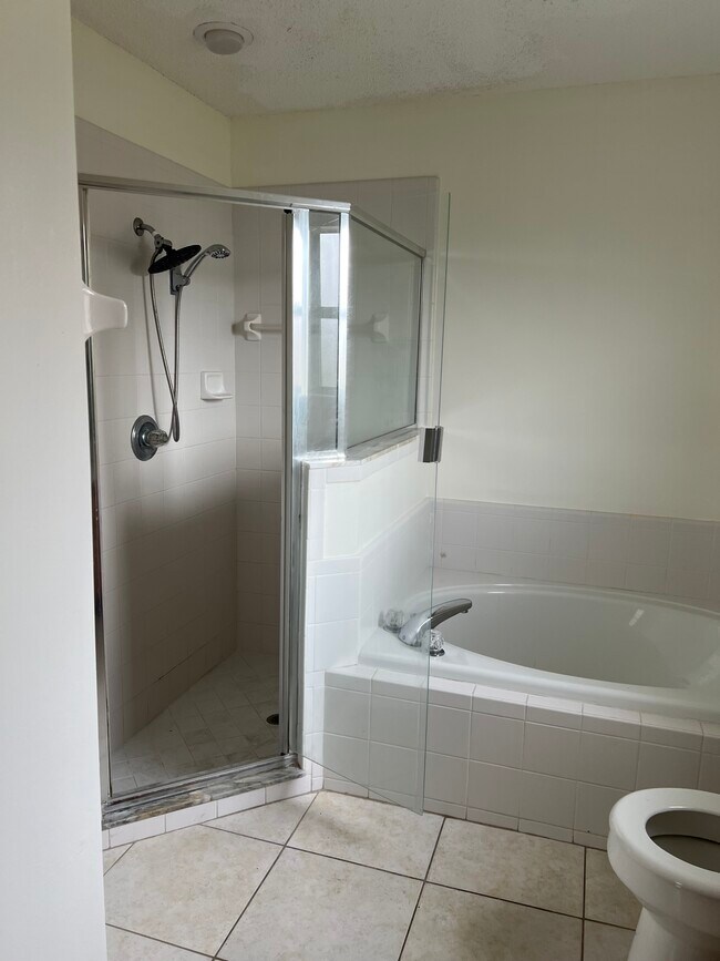 El baño principal cuenta con una relajante bañera de hidromasaje y lavabos dobles, perfecto para una pareja. - 5374 Lacy Jane Way