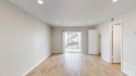 Located at 6000 Boca Raton Blvd in Fort Worth, TX, this single-floor unit offers a well-organized layout comprising a living room, kitchen, closet, and bathroom. The living area is bright and open, finished with light wood-style flooring and neutral warm-gray walls that create a clean, welcoming atmosphere. Recessed lighting and a textured ceiling complement the space, while a full-length sliding glass door floods the room with natural light and provides outdoor views. A separate window on the adjacent wall adds additional brightness. The kitchen features modern gray cabinetry with brushed nickel hardware, granite-style countertops, and wood-style flooring that flows seamlessly throughout the unit. A utility access panel is conveniently located in the kitchen area. The walk-in closet offers dual hanging rods on opposing walls, providing ample storage for its size. The bathroom includes a full tub-shower combo with white tile surround, brushed nickel fixtures, and a grab bar for added convenience. Clean white trim and baseboards throughout the unit tie the design together, giving the space a fresh and well-maintained appearance.