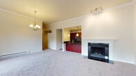 Located at 10290 NE 12th Street in the heart of Bellevue, WA, this well-appointed residence offers a thoughtfully designed single-floor layout with a variety of standout features throughout. The spacious living area is anchored by a classic fireplace with tile surround and flows seamlessly toward large sliding glass doors and oversized windows that invite abundant natural light and provide views of the surrounding greenery and neighborhood. An elegant chandelier adds a refined touch to the open living and dining space.

The kitchen is a functional highlight, featuring rich cherry cabinetry, dark granite countertops, stainless steel appliances including a range and over-the-range microwave, and a striking mosaic tile backsplash. A breakfast bar peninsula opens the kitchen to the living area, while a walk-in pantry with built-in shelving provides generous storage.

The bedrooms are carpeted and generously sized, with one room offering tranquil outdoor views through a large window with transom detail. Closet space is well-planned, with a dedicated closet featuring a built-in rod and shelf system.

The bathroom is finished with warm tile flooring, dark granite vanity countertops, rich wood cabinetry, and a tub-shower combination enclosed by sliding glass doors. A dedicated in-unit laundry area with a full-size washer and dryer completes this well-rounded home.