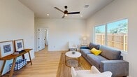 Located in Seguin, TX, this thoughtfully designed single-story home offers a clean, modern aesthetic with an efficient and functional layout. Light wood flooring flows throughout, complementing the crisp white walls and contemporary black hardware accents found across every room.

The open-concept living area is bright and welcoming, featuring a ceiling fan with integrated lighting and a large window that frames outdoor views and draws in abundant natural light. The kitchen is a standout, outfitted with white shaker-style cabinetry, white subway tile backsplash, light quartz countertops, stainless steel appliances including a gas range, dishwasher, and refrigerator, and a deep single-basin sink — all accessible to a dining area with direct outdoor access.

Both bedrooms are comfortably sized, with the primary bedroom offering ample space, dual windows, and a ceiling fan. The second bedroom is equally bright, with a window overlooking the fenced yard. A closet provides convenient storage between rooms.

The two bathrooms echo the home's modern style, each featuring white shaker vanities with black fixtures, white subway tile shower surrounds, and warm vanity lighting. The exterior includes a fenced yard with a patio area, offering a private outdoor retreat. This home combines clean design with practical living in a compact, well-appointed package.