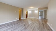 Located at 229 Amherst Drive in Amherstview, Ontario, this 2-bedroom, 1-bathroom unit offers a thoughtfully designed single-floor layout with modern updates throughout. Light-toned luxury vinyl plank flooring flows consistently across every room, creating a cohesive and easy-to-maintain living space.

The living room is generously proportioned, featuring a large picture window that fills the room with natural light and frames views of surrounding greenery. Warm neutral walls and baseboard heating add to the comfortable atmosphere. The layout connects smoothly to the kitchen, which is fitted with crisp white cabinetry, dark countertops, and stainless steel appliances including an electric range and over-the-range microwave.

Both bedrooms are well-sized, with the primary bedroom featuring a mirrored sliding closet and windows overlooking the natural outdoor setting. The second bedroom also benefits from natural light and a mirrored closet, maximizing the sense of space.

The bathroom is a standout feature, showcasing a soaker tub with a full surround of large-format marble-effect tiles in white with elegant grey veining, paired with chrome fixtures and continued vinyl plank flooring.

A welcoming hallway with a mirrored closet completes this clean and move-in-ready space.