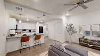Located at 1800 Frontier Rd in Barling, Arkansas, this well-appointed one-bedroom, one-bathroom unit delivers a thoughtfully designed, single-level floor plan. Wood-look plank flooring runs throughout, tying together a clean, contemporary aesthetic accented by crisp white walls and recessed lighting.

The open-concept living area is bright and welcoming, featuring a ceiling fan, large windows with horizontal blinds that allow ample natural light, and enough space to accommodate a full seating arrangement. This area flows directly into the kitchen, which stands out as a functional centerpiece of the home. White shaker-style cabinetry reaches to the ceiling, paired with granite countertops, a peninsula breakfast bar with seating for two, pendant lighting, and black appliances including a range, microwave, and refrigerator.

The bedroom is a comfortable, well-proportioned retreat with a ceiling fan, a window for natural light, and direct access to a dedicated closet. The bathroom features granite-topped white vanity cabinetry, a tub-shower combination, and wood-look flooring. A separate laundry room with an in-unit washer and dryer hookup and overhead shelving adds everyday convenience to this efficiently designed home.