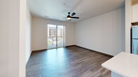 Located at 6219 Williamsburg Way in De Forest, Wisconsin, this single-floor 1-bedroom, 1-bathroom residence offers a thoughtfully designed layout with modern finishes throughout. The kitchen is a standout feature, showcasing white shaker-style cabinetry, a classic subway tile backsplash, quartz countertops, and a large center island. Stainless steel appliances — including a refrigerator, range, microwave, and dishwasher — complete the space, while stylish pendant lighting adds a refined touch overhead. Durable wood-look flooring runs through the main living areas, complementing the clean, contemporary aesthetic. The living area is bright and open, with a ceiling fan, sliding glass doors that lead to a private balcony, and views of the surrounding community. The bedroom offers comfortable carpeting, a ceiling fan, and a window that brings in natural light. A dedicated closet provides practical storage. The bathroom features a white vanity with ample counter space, a framed mirror, wood-look flooring, and a full tub-shower combination with sleek chrome fixtures. Dark hardware accents and clean white walls tie the design together throughout the home, creating a cohesive, modern living environment.