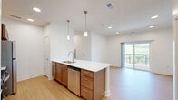 Located at 2300 Honey B Lane in Blair, Nebraska, this single-floor residence offers a thoughtfully designed layout with 2 bedrooms, 2 bathrooms, a kitchen, and a dedicated closet. The kitchen is a standout feature, equipped with warm-toned wood cabinetry, stainless steel appliances including a refrigerator, electric range, and microwave, complemented by a white quartz countertop that extends into a spacious island with a stainless steel sink. A subway tile backsplash and pendant lighting add a clean, modern aesthetic, while light wood-style flooring runs throughout the kitchen and bathrooms. The two bathrooms are finished with matching warm wood vanities, white quartz countertops, and tub-shower combinations, all set on the same light wood-style flooring for a cohesive look. Both bedrooms feature neutral carpet, crisp white walls, and ceiling fans with lighting. Natural light enters through blinded windows that offer views of the surrounding landscape. The primary bedroom provides a comfortable and generously sized retreat. Throughout the residence, the design maintains a consistent, contemporary palette of whites and warm wood tones, creating a clean and inviting atmosphere.
