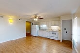 Located at 750 Harding Blvd in Baton Rouge, Louisiana, this single-floor, one-bedroom, one-bathroom unit offers a practical and comfortable layout. The open-concept living and kitchen area forms the heart of the space, with light wood laminate flooring running throughout and a ceiling fan overhead that adds both function and visual continuity. The kitchen is positioned along one wall and features white cabinetry, granite-style countertops, a double sink, and white appliances including a refrigerator, electric range, and dishwasher. A window along the living area invites natural light, creating a bright and airy atmosphere. A hallway connects the main living space to the private quarters, providing a clear separation between living and sleeping areas. The bedroom is a comfortable size, equipped with its own ceiling fan, a closet, and a window with a roller shade for light control. The bathroom is clean and efficiently arranged, with a white vanity cabinet topped with a granite-style surface, a well-lit mirror with overhead lighting, and wood-look flooring that ties into the rest of the unit. Neutral wall tones throughout the space provide a versatile backdrop, making it easy to personalize. The unit offers a functional, low-maintenance layout well-suited for single occupants or couples.