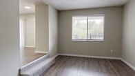 Located at 3400 Townsend Blvd in Jacksonville, Florida, this 2-bedroom, 2-bathroom residence offers a well-organized single-floor layout designed for comfortable everyday living. The two living areas provide flexible spaces for relaxation or entertaining, with one featuring durable wood-style flooring and a sliding glass door that opens to a private balcony with outdoor views, while vertical blinds offer adjustable light control. A second living area also includes a sliding glass door, bringing in natural light and continuing the connection to the outdoors. The kitchen is a functional highlight, outfitted with grey shaker-style cabinetry, a white subway tile backsplash, light countertops, a double basin sink, and black appliances including a refrigerator and dishwasher, all set on wood-style flooring. The spacious primary bedroom features plush carpet flooring, a large window for natural light, and ample closet storage with bifold doors. The second bedroom is similarly carpeted and well-proportioned. Both bathrooms are finished with wood-style flooring, full tub-shower combinations with tiled surrounds, and white vanities. A connecting hallway ties the layout together, and neutral warm-toned walls throughout create a clean, cohesive aesthetic.