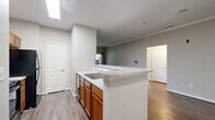 This well-appointed 2-bedroom, 1-bathroom residence on Lottsford Road in Upper Marlboro, Maryland offers a thoughtfully designed single-floor layout. The open-concept living and kitchen area serves as the heart of the home, where rich hardwood-style flooring flows throughout. A classic white-mantled fireplace anchors the living room, adding warmth and character. The kitchen features warm oak cabinetry, light granite-style countertops, black appliances including a refrigerator and microwave, and a raised breakfast bar that connects seamlessly to the living space. Crown molding in the main living area adds an elegant finishing touch. The spacious primary bedroom offers ample room, with dual windows providing generous natural light and outdoor views of the lush surroundings. The second bedroom is also well-sized, with its own window for natural light. Both bedrooms feature the same hardwood-style flooring found throughout the home. The full bathroom is clean and functional, equipped with a tiled tub-shower combination. A hallway connects the main living areas to the bedrooms, and two dedicated closets provide practical storage solutions. Neutral gray tones throughout create a calm, move-in-ready ambiance.