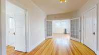 Located in Denver's vibrant Capitol Hill neighborhood, this single-floor residence at 1535 N Grant St blends classic character with thoughtful updates throughout. Rich, warm hardwood floors extend across the living areas, reflecting natural light and adding a timeless quality to the home.

The living room is anchored by a charming brick fireplace with a clean white mantle, creating an inviting focal point. Elegant French doors with glass panes connect the living and dining areas, allowing light to flow freely between rooms while offering a refined architectural detail. Cast-iron radiators throughout the home speak to its historic character while providing efficient heating.

Multiple windows — including multi-pane sash windows — fill the rooms with abundant natural light. Several spaces are accented by decorative ceiling light fixtures, adding warmth and personality. A ceiling fan in the bedroom provides additional comfort.

The kitchen has been thoughtfully updated with white shaker cabinetry, dark countertops, a white subway tile backsplash, stainless steel gas range, and dark slate-style tile flooring. A window above the sink brings in natural light.

The bathroom features classic white hexagonal floor tile and subway-tiled walls, maintaining a cohesive, clean aesthetic throughout the home. Every room reflects a careful balance of historic charm and modern convenience.