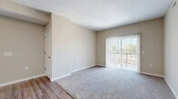 This well-appointed three-bedroom, two-bathroom residence in Blacklick, Ohio offers a thoughtfully designed single-floor layout with a comfortable and functional living experience. The open-concept living area features a combination of wood-look plank flooring and plush carpeting, with large sliding glass doors fitted with vertical blinds that flood the space with natural light and provide direct access to a private balcony with outdoor views.

The kitchen is a standout feature, showcasing rich dark-wood cabinetry, light granite-style countertops, a breakfast bar peninsula ideal for casual dining, and black appliances including a refrigerator, stove, and microwave. A double-basin sink and ample cabinet storage complete this practical and stylish space.

Each of the three carpeted bedrooms offers a comfortable retreat, with the primary bedroom providing generous proportions. All bedrooms are equipped with sliding-door closets featuring wire shelving, and the unit boasts an impressive nine closets total, ensuring exceptional storage throughout. A dedicated laundry area and utility room add further convenience.

The two bathrooms are finished with large-format tile flooring and dark-wood vanities. The primary bath includes a walk-in glass-door shower, while the secondary bath features grab bars for added accessibility. Neutral warm-toned walls throughout the unit create a clean, inviting ambiance.