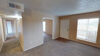 This single-floor unit in Abilene offers a straightforward, functional layout with warm neutral tones throughout. The living area is generously sized, featuring plush carpeting, textured ceilings, and a large window that allows natural light to fill the space. A front entryway with wood-look flooring transitions smoothly into the main living area, and an open passage connects to an additional room, adding flexibility to the floor plan.

The kitchen is designed for efficiency, featuring dark cabinetry on both sides, speckled countertops, a stainless sink, and a black electric range with overhead ventilation. Wood-look flooring runs through this area, providing a durable and easy-to-maintain surface.

The bedrooms are carpeted and well-proportioned, each equipped with a ceiling fan with light fixture and window with blinds, ensuring comfortable airflow and natural light. The neutral wall tones create a clean, versatile backdrop throughout.

The bathroom includes a combined tub and shower with tiled surround, a toilet, a vanity with a speckled countertop, and wood-look flooring. A towel bar and overhead ventilation are also present. Overall, the space presents a practical and livable environment suited for everyday comfort.
