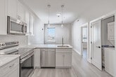 Located in Philadelphia's vibrant Northern Liberties neighborhood, this 1-bedroom, 1-bathroom unit at 342 W Girard Ave offers a thoughtfully designed layout with modern finishes throughout. The open-concept kitchen serves as the heart of the space, featuring white shaker cabinetry, marble-look quartz countertops with a subway tile backsplash, a full suite of stainless steel appliances including a refrigerator, electric range, built-in microwave, and dishwasher, and elegant pendant lighting over a central island with an undermount sink. Light hardwood flooring flows seamlessly throughout the unit, complementing the crisp white walls and creating a clean, contemporary aesthetic. The bedroom offers a comfortable footprint with a natural light source via a window with city views, and connects directly to a well-organized walk-in closet featuring built-in shelving, hanging rods, and ample storage capacity. The full bathroom is finished with striking marble-look floor tile, a tiled tub-shower combination, and a modern floating vanity, providing a polished, spa-like feel. The overall design emphasizes clean lines, bright interiors, and efficient use of space, making this unit a compelling option in the heart of Philadelphia.