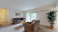 This single-floor residence at 1800 Laurel Rd in Lindenwold, New Jersey offers a well-organized and comfortable layout with a variety of thoughtfully designed spaces. The living room serves as the heart of the home, featuring plush carpeted flooring, neutral walls, and a large sliding glass door flanked by vertical blinds that floods the room with natural light and provides direct access to an outdoor view. A secondary sitting area highlights a wide bay window with horizontal blinds, adding architectural interest and additional natural light.

The kitchen is a standout space, showcasing rich, dark cabinetry paired with striking granite-style countertops, a stainless steel sink, and a stainless steel range — offering both style and functionality. Tile flooring completes the clean, practical aesthetic of this well-equipped cooking area.

The bedrooms are carpeted and serene, with each room featuring windows that invite natural light. The primary bedroom is generously proportioned with ample space for large furniture and includes access to a closet. The clean, white bathroom is efficiently laid out with a combination tub and shower, a vanity with cabinetry below, and tile flooring throughout.

Overall, the space presents a warm, neutral palette with consistent finishes that create a cohesive and inviting atmosphere throughout.