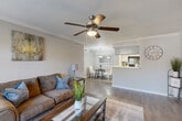 Located at 10615 Meadowglen Ln in Houston, TX, this well-designed single-floor, one-bedroom, one-bathroom residence makes smart use of its space through a thoughtful, open-concept layout. The living room serves as the heart of the home, featuring wood-style flooring, crown molding, a ceiling fan with light fixture, and a textured ceiling. Large windows allow natural light to fill the room, creating a bright and welcoming atmosphere. The living area flows seamlessly into the dining room, which is anchored by a pendant light fixture and connects directly to the kitchen. The kitchen is equipped with black appliances, a mosaic tile backsplash, ample cabinetry, a pantry, and a breakfast bar with a white countertop that opens to the dining area — ideal for casual meals or entertaining. The bedroom offers a comfortable retreat with its own ceiling fan, natural light from a window with exterior views, and convenient access to a dedicated closet. Two additional closets throughout the unit provide generous storage. The bathroom features a clean, white tiled tub-shower combination. Crown molding details in the main living areas add a refined touch throughout, tying together the cohesive, neutral color palette of the entire home.