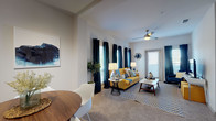This single-story 2-bedroom, 2-bathroom residence offers a well-planned layout that balances comfort and functionality. The open-concept kitchen flows seamlessly into the living and dining areas, featuring dark espresso cabinetry, light quartz countertops, a subway tile backsplash, stainless steel appliances including a refrigerator, range, microwave, and dishwasher, and durable wood-style flooring. A kitchen island with an undermount sink adds practical workspace and visual separation between the kitchen and living areas. The living room is bright and inviting, with multiple windows dressed in floor-length drapes, a ceiling fan, and direct access to an exterior door. Both bedrooms are generously sized with plush carpeting, ceiling fans, and large windows that allow ample natural light. The primary bathroom features an elongated vanity with dark cabinetry, light countertops, a large mirror, recessed lighting, wood-style flooring, and a walk-in closet. The secondary bathroom offers a clean tub-shower combination with tile surround and wood-style flooring. Neutral wall tones and consistent modern finishes throughout create a cohesive and contemporary living environment.
