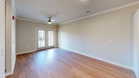 Located at 4415 Percival Rd in Columbia, SC, this thoughtfully designed one-bedroom, two-bathroom residence offers an efficient and comfortable single-floor layout. Warm hardwood-style flooring flows throughout the home, complemented by neutral wall tones and crown molding that add a refined touch to the living areas. The open living room is bright and airy, featuring a ceiling fan, crisp white trim, and glass French doors that invite natural light and provide outdoor access. The kitchen is a standout, showcasing white shaker cabinetry, stainless steel appliances including a refrigerator, electric range, and built-in microwave, along with a central island with pendant lighting and a sink — ideal for both cooking and casual dining. The bedroom is comfortably sized, with a ceiling fan, natural light from a large window, and views of the surrounding neighborhood. Two full bathrooms serve the home, one featuring a white double-sink vanity with modern fixtures and a large mirror, the other with a soaking tub and tiled surround. A dedicated laundry room with a full-size washer and dryer adds everyday convenience. A closet provides additional storage, completing this well-rounded and move-in-ready residence.