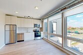 Located at 2310 Cochrane St in Detroit's vibrant Corktown neighborhood, this efficient 1-bedroom, 1-bathroom unit offers a thoughtfully designed modern layout across a single floor. Light ash-toned hardwood floors run throughout, creating a clean, cohesive aesthetic that ties each space together.

The open-concept living, dining, and kitchen area serves as the heart of the unit. The kitchen is outfitted with light wood cabinetry extending to the ceiling for ample storage, a full suite of stainless steel appliances including a refrigerator, dishwasher, electric range, and built-in microwave, and a single-basin sink. Exposed industrial-style ductwork adds a contemporary urban character. Large floor-to-ceiling windows flood the living area with natural light and frame sweeping views of the Detroit skyline and surrounding cityscape.

The bedroom is a well-proportioned, quiet retreat featuring its own window with city views, a closet, and the same warm hardwood flooring. The bathroom is clean and functional, featuring a tub-shower combo, toilet, and vanity with ample counter space. Additional features include two closets and an in-unit laundry area, providing practical convenience. The overall ambiance is bright, modern, and urban.