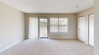 Located at 5855 Old Oak Ridge Rd in Greensboro, NC, this single-floor 2-bedroom, 1-bathroom residence offers a practical and comfortable layout. The interior is finished with neutral beige tones and plush wall-to-wall carpeting throughout the main living and bedroom areas, creating a warm and cohesive aesthetic.

The living area features a sliding glass door that opens to a private deck, accompanied by a large window that allows natural light to fill the space and provides views of surrounding greenery. The entry area transitions between carpet and hardwood-style flooring near the front door, adding visual interest to the layout.

The kitchen is thoughtfully designed with gray cabinetry, granite-style countertops, a double stainless steel sink, and a window above the sink that brings in additional natural light — a functional and attractive workspace.

The spacious primary bedroom offers generous proportions and a closet for storage. The second bedroom is bright and well-sized, featuring a window with outdoor views and soft carpeting. Both rooms are finished with clean white trim and neutral walls.

The bathroom includes a full tub-shower combination with chrome fixtures, maintaining a clean and simple design. Overall, this residence provides a well-organized, move-in ready living space in a convenient Greensboro location.