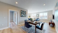 Located at 455 Livingston St in Norwood, NJ, this well-designed single-floor residence offers a thoughtfully laid-out living space with a clean, modern aesthetic throughout. Light hardwood flooring runs seamlessly across the entire unit, lending warmth and visual continuity from room to room.

The open-concept living and dining area serves as the heart of the home, bathed in natural light from multiple large windows that frame outdoor views. The dining space comfortably accommodates a full dining set, while the adjacent living area provides ample room for relaxed seating and entertainment.

The kitchen features dark cabinetry with granite-style countertops, stainless steel appliances including a gas range and dishwasher, and a practical galley-style layout that maximizes efficiency.

The generously sized bedroom offers natural light through a large window, double closet doors, and plenty of room to furnish comfortably. A dedicated home office or flex room provides a bright, functional workspace with outdoor views.

Two bathrooms serve the residence: one full bathroom with a walk-in tiled shower, dark vanity with granite countertop, and tile flooring, and a second bathroom with similarly refined finishes. Neutral gray walls throughout create a cohesive, contemporary backdrop that complements the home's modern character.
