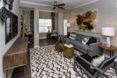 This single-floor residence at 6038 Hixson Pike in Hixson, Tennessee, offers a thoughtfully designed open-concept layout with contemporary finishes throughout. The kitchen serves as a central hub, featuring granite countertops, gray shaker-style cabinetry, stainless steel appliances, and a large peninsula with bar seating illuminated by pendant lighting. It flows directly into the dining area, which is distinguished by crown molding, a chandelier, and an accent wall, creating an elegant yet functional space for entertaining.

The living room provides a comfortable gathering space with a ceiling fan, textured accent wall, and natural light from multiple windows. An adjacent flex area functions as a home office or sitting room. The bedrooms are carpeted and well-sized, each featuring ceiling fans and ample natural light. The bathrooms are finished with granite-topped vanities, gray cabinetry, and wood-look flooring. A dedicated laundry area with full-size washer and dryer hookups adds everyday practicality. Throughout the residence, warm-toned walls, wood-look flooring in main living areas, and consistent modern detailing create a cohesive and inviting atmosphere.