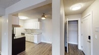 This single-floor unit offers a thoughtfully designed layout that balances functionality and comfort throughout its living spaces. The open-concept living and dining area is finished with durable wood-look flooring and features a textured ceiling, a ceiling fan, and sliding door access to a private balcony with outdoor views, allowing natural light to fill the space.

The galley-style kitchen is well-equipped and features white shaker cabinetry on both sides, light granite countertops, a stainless steel refrigerator, electric range, built-in dishwasher, and a single-basin sink. Wood-look flooring continues seamlessly through the kitchen, and flush ceiling lighting provides ample illumination.

The bedroom is carpeted for comfort and includes dual reach-in closets with built-in shelving and hanging rods, providing generous storage. The textured ceiling and neutral wall tones carry throughout, creating a cohesive aesthetic.

The bathroom is finished with white cabinetry, granite countertops, an undermount sink, and brushed nickel hardware and fixtures. Wood-look flooring extends into the bathroom, complementing the clean, updated design. A coat closet near the entry area adds additional storage convenience. Overall, the unit presents a clean, modern interior with consistent finishes throughout.