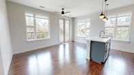 This contemporary 1180 square foot home in Austin, TX offers a harmonious blend of style and functionality. The single-story layout features three bedrooms and three bathrooms, ideal for comfortable family living or hosting guests. The heart of the home is the open-concept kitchen and living area, showcasing a modern design with white upper cabinets, contrasting lower blue cabinets, and sleek stainless steel appliances. A large center island with pendant lighting serves as a focal point, perfect for casual dining or entertaining.

Throughout the home, warm wood flooring creates a cohesive and inviting atmosphere. Large windows in every room flood the space with natural light and offer picturesque views of the surrounding landscape. The primary bedroom, measuring 140 square feet, provides a spacious retreat with an en-suite bathroom and a walk-in closet featuring built-in shelving and hanging space.

The bathrooms are designed with a modern aesthetic, featuring clean lines, white fixtures, and gray vanities. Each of the three bedrooms is equipped with a ceiling fan for comfort and boasts ample closet space. The home's layout is thoughtfully designed to maximize space efficiency while maintaining an open and airy feel. With its combination of contemporary design and practical amenities, this Austin home offers a desirable living space in a sought-after location.