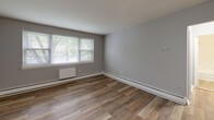 Located at 875 N Easton Rd in Glenside, PA, this one-bedroom, one-bathroom unit offers a thoughtfully organized layout across a single floor. The interior is finished with warm wood-look luxury vinyl plank flooring that runs consistently throughout the living areas and bedroom, lending a cohesive and clean aesthetic to the space.

The kitchen is compact yet functional, outfitted with white shaker-style cabinetry, a subway tile backsplash, a stainless steel refrigerator, and a stainless steel range, providing a modern and efficient cooking space. The living area is bright and open, with neutral gray walls and a window that draws in natural light and views of surrounding greenery.

The bedroom is a comfortable, well-proportioned room featuring multiple windows that flood the space with natural light. A full-width closet with sliding doors provides ample storage. Baseboard heating units are present throughout, ensuring year-round comfort.

The bathroom is clean and simply appointed, with white subway tile surrounding a full soaking tub and shower combo, complemented by chrome fixtures and a bright, neutral palette. A hallway connects the rooms, keeping the layout efficient and accessible. Overall, the unit presents a fresh, move-in-ready feel with updated finishes throughout.