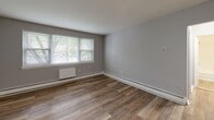 Located at 875 N Easton Rd in Glenside, PA, this one-bedroom, one-bathroom unit offers a thoughtfully organized layout across a single floor. The interior is finished with warm wood-look luxury vinyl plank flooring that runs consistently throughout the living areas and bedroom, lending a cohesive and clean aesthetic to the space.

The kitchen is compact yet functional, outfitted with white shaker-style cabinetry, a subway tile backsplash, a stainless steel refrigerator, and a stainless steel range, providing a modern and efficient cooking space. The living area is bright and open, with neutral gray walls and a window that draws in natural light and views of surrounding greenery.

The bedroom is a comfortable, well-proportioned room featuring multiple windows that flood the space with natural light. A full-width closet with sliding doors provides ample storage. Baseboard heating units are present throughout, ensuring year-round comfort.

The bathroom is clean and simply appointed, with white subway tile surrounding a full soaking tub and shower combo, complemented by chrome fixtures and a bright, neutral palette. A hallway connects the rooms, keeping the layout efficient and accessible. Overall, the unit presents a fresh, move-in-ready feel with updated finishes throughout.