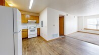 Located at 1407 S 7th Ave in Marshalltown, Iowa, this single-floor unit offers three bedrooms and two bathrooms within a well-organized, efficiently laid-out floor plan. The kitchen features warm oak cabinetry, light countertops, and wood-style vinyl flooring, and is equipped with a full suite of appliances including a refrigerator, electric range, dishwasher, and range hood. The open sightline from the kitchen toward the living area creates a connected, functional flow throughout the main space. Each of the three bedrooms is carpeted and finished with neutral white walls and warm wood baseboards, providing a clean and versatile canvas. The bedrooms benefit from natural light through standard windows with blinds, and several rooms include sliding-door closets for practical storage. The primary bedroom offers a comfortable amount of space for everyday living. The two bathrooms are consistent in finish, each featuring an oak vanity with a single-basin sink, a lighted mirror, and hard-surface flooring. One bathroom includes a full tub-shower combination. A connecting hallway ties the rooms together efficiently. Throughout the unit, the consistent use of light tones and warm wood accents creates a cohesive, approachable aesthetic suited for a variety of residents.