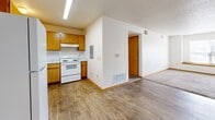 Located at 1407 S 7th Ave in Marshalltown, Iowa, this single-floor unit offers three bedrooms and two bathrooms within a well-organized, efficiently laid-out floor plan. The kitchen features warm oak cabinetry, light countertops, and wood-style vinyl flooring, and is equipped with a full suite of appliances including a refrigerator, electric range, dishwasher, and range hood. The open sightline from the kitchen toward the living area creates a connected, functional flow throughout the main space. Each of the three bedrooms is carpeted and finished with neutral white walls and warm wood baseboards, providing a clean and versatile canvas. The bedrooms benefit from natural light through standard windows with blinds, and several rooms include sliding-door closets for practical storage. The primary bedroom offers a comfortable amount of space for everyday living. The two bathrooms are consistent in finish, each featuring an oak vanity with a single-basin sink, a lighted mirror, and hard-surface flooring. One bathroom includes a full tub-shower combination. A connecting hallway ties the rooms together efficiently. Throughout the unit, the consistent use of light tones and warm wood accents creates a cohesive, approachable aesthetic suited for a variety of residents.