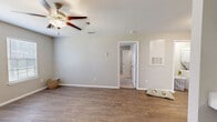 Located in Burleson, TX, this one-bedroom, one-bathroom unit offers a well-designed layout across a single floor. The combined kitchen and living area forms the heart of the home, with wood-look flooring flowing throughout the open space, neutral gray walls, and ample natural light from white-blinded windows. The kitchen is a standout feature, boasting rich dark espresso cabinetry, light countertops, a stainless steel sink, and black and stainless appliances, including a built-in microwave and range — all set within a functional galley-style layout. The living area is open and versatile, offering plenty of room to configure a comfortable living arrangement. The bedroom is generously sized, featuring soft carpeting, a ceiling fan with light kit, and multiple windows that invite natural light, along with access to a private door leading outside. The bathroom is tastefully finished with large-format gray tile surrounding a full soaking tub and shower combination, complemented by brushed nickel fixtures. Clean white trim and a consistent neutral palette throughout the unit create a cohesive, move-in-ready aesthetic well-suited for comfortable everyday living.