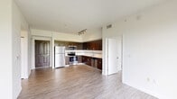 Located at 13113 SW 248th St in Homestead, FL, this single-floor, 2-bedroom, 2-bathroom residence offers a clean, modern aesthetic throughout. The open kitchen is a standout feature, showcasing rich dark-wood cabinetry extending floor to ceiling, light countertops, a tiled backsplash with decorative accent trim, and a full suite of stainless steel appliances including a refrigerator, range, microwave, and dishwasher. Track lighting overhead adds a contemporary touch. Light wood-look flooring runs throughout the living areas and bedrooms, creating a warm, cohesive feel. The spacious primary bedroom features a ceiling fan and a generous closet with bi-fold doors, while the second bedroom also includes a ceiling fan and access to an outdoor-facing window with views of surrounding greenery. Both bathrooms are finished with light tile flooring, white subway-tiled tub-shower combinations, chrome fixtures, and dark wood vanities that complement the kitchen's design language. A connecting hallway provides a logical flow between the bedrooms and bathrooms. The overall ambiance is bright, clean, and contemporary, well-suited for comfortable everyday living in South Florida.