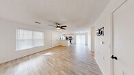 Located at 640 E Sunset St in Springfield, MO, this single-story, 2-bedroom, 1-bathroom home offers a well-organized and functional layout. The open-concept living and dining area is highlighted by light wood-style flooring, crisp white walls, a textured ceiling, and a ceiling fan with integrated lighting. Large windows with blinds allow natural light to fill the space. The kitchen is positioned at the heart of the home and features white cabinetry, a peninsula with a white countertop, stainless steel appliances including a range, microwave, and refrigerator, and a stylish overhead light fixture. A sliding glass door in the dining area provides additional light and access. Both bedrooms are carpeted and equipped with ceiling fans and closets — one bedroom features a double-door closet and a window. The shared full bathroom includes a white vanity with under-cabinet storage, a framed mirror, matte black fixtures, and a tub/shower combo with light wood-style flooring. Additional spaces include a laundry area, utility room, hallway, and multiple closets for storage. The attached garage offers a spacious concrete floor area with an automatic opener and direct interior access, completing this practical and well-appointed home.