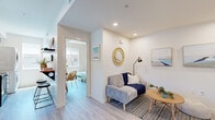 Located at 2915 E St in San Diego, CA, this two-story, two-bedroom, one-bathroom home offers a thoughtfully designed layout spread across two floors. The ground floor provides a compact yet functional entry point, while the upper floor houses the majority of the living space, including the bedrooms, kitchen, bathroom, and a welcoming living area.

The living area features light wood-look flooring, crisp white walls, and recessed lighting, creating a bright and airy atmosphere. A cozy seating nook with coastal-inspired décor adds warmth to the space. The kitchen is outfitted with white flat-front cabinetry, quartz countertops, black hardware, and black stainless steel appliances including a dishwasher, range, microwave, and refrigerator, all centered around a window that brings in natural light.

The primary bedroom offers a comfortable, sunlit retreat with a large window framing neighborhood views. The second bedroom is equally bright, featuring a generous window with an outdoor view and coastal artwork that reflects the San Diego setting. Both rooms are finished with the same light flooring found throughout the home.

The bathroom is finished with a dual-sink white vanity, quartz countertops, black fixtures, and large mirrors, conveying a clean, modern aesthetic. Two staircases connect the floors, complemented by a hallway that ensures smooth circulation throughout the home.